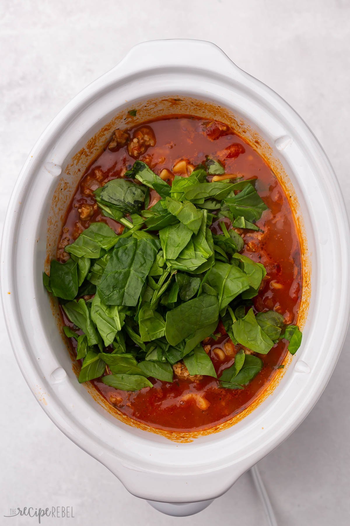soupe de lasagne cuite avec des épinards frais posés dessus.