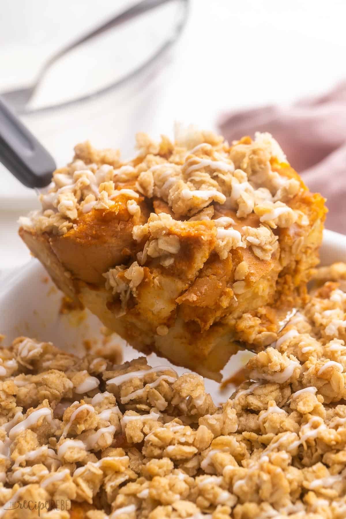 une portion de casserole de pain perdu à la citrouille étant prélevée du plat.