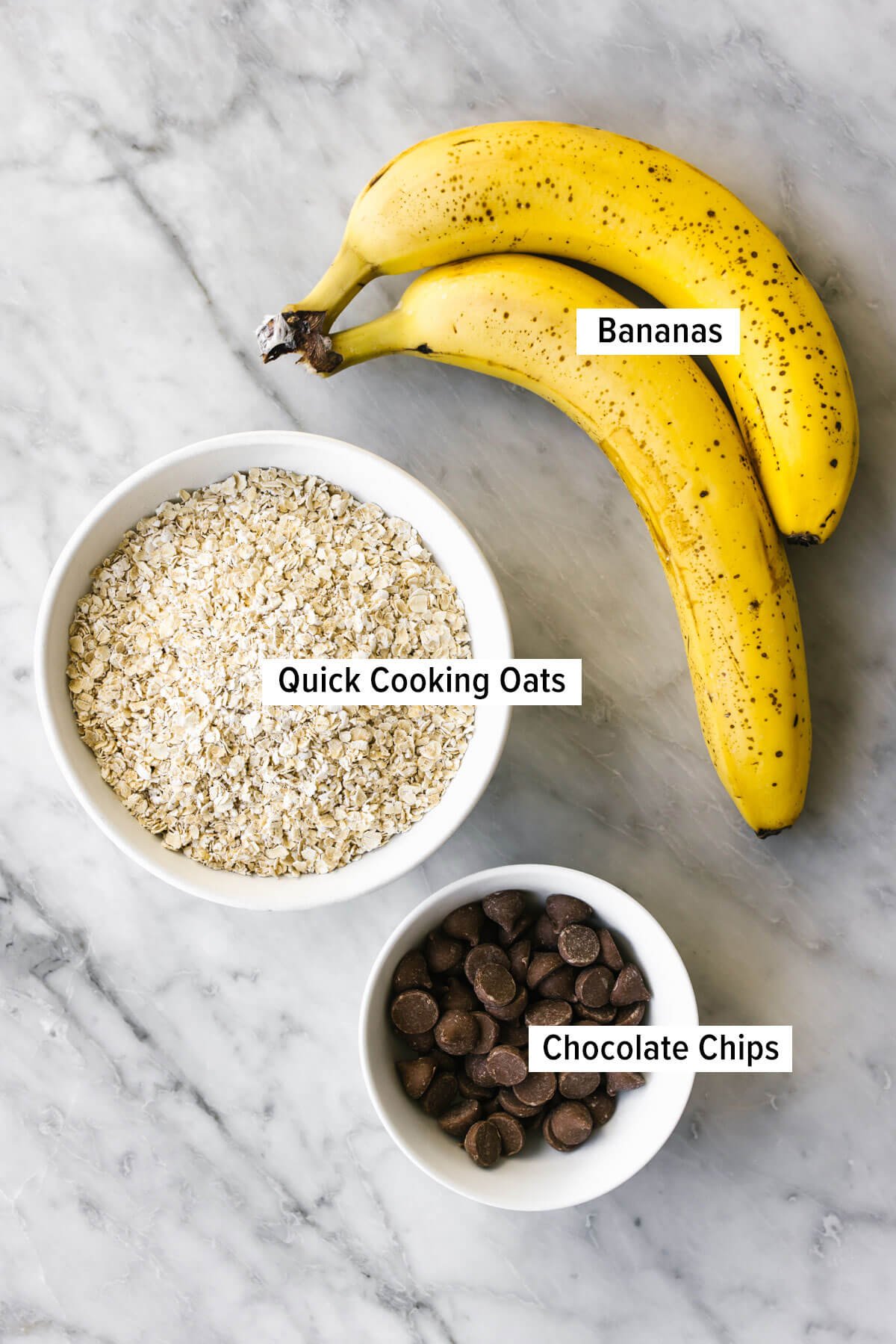 Les meilleurs cookies à la banane et à l'avoine avec 3 ingrédients, irrésistiblement moelleux et incroyablement faciles à réaliser, parfaits pour un dessert sain ! Ingrédients pour des cookies à la banane et à l'avoine sur une table.