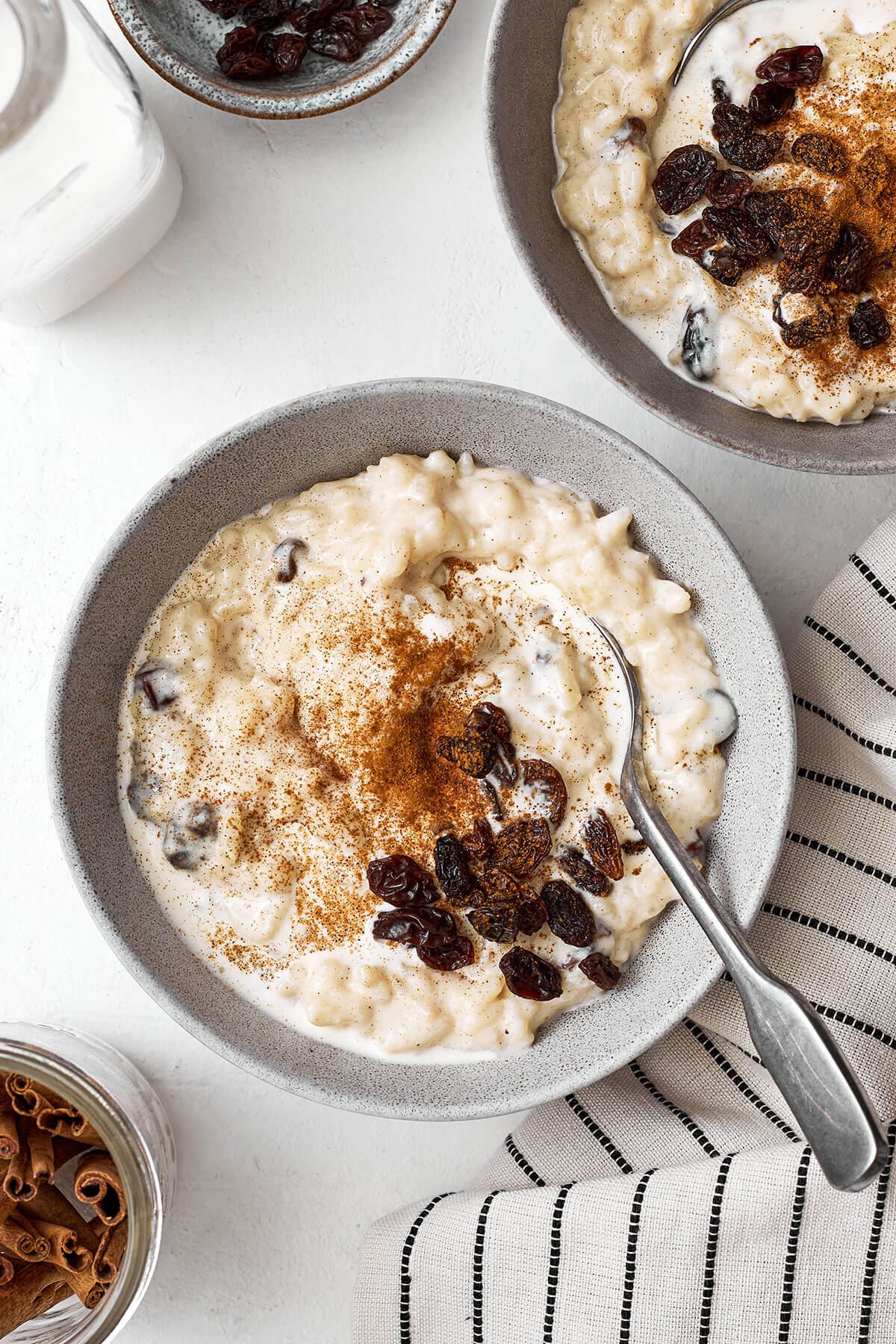 Cette recette facile de riz au lait est le dessert parfait pour les fêtes à déguster cet hiver ! Une cuillère avec du riz au lait dans un bol