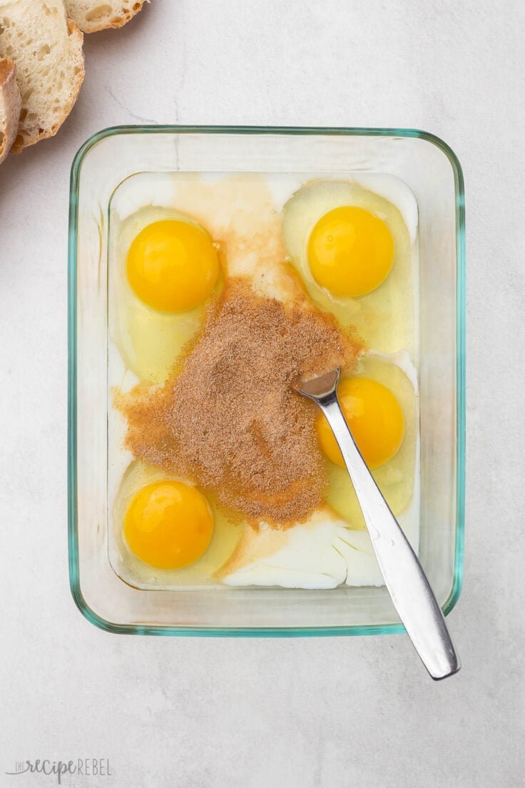un plat en verre rempli d'ingrédients mélangés pour le pain perdu.