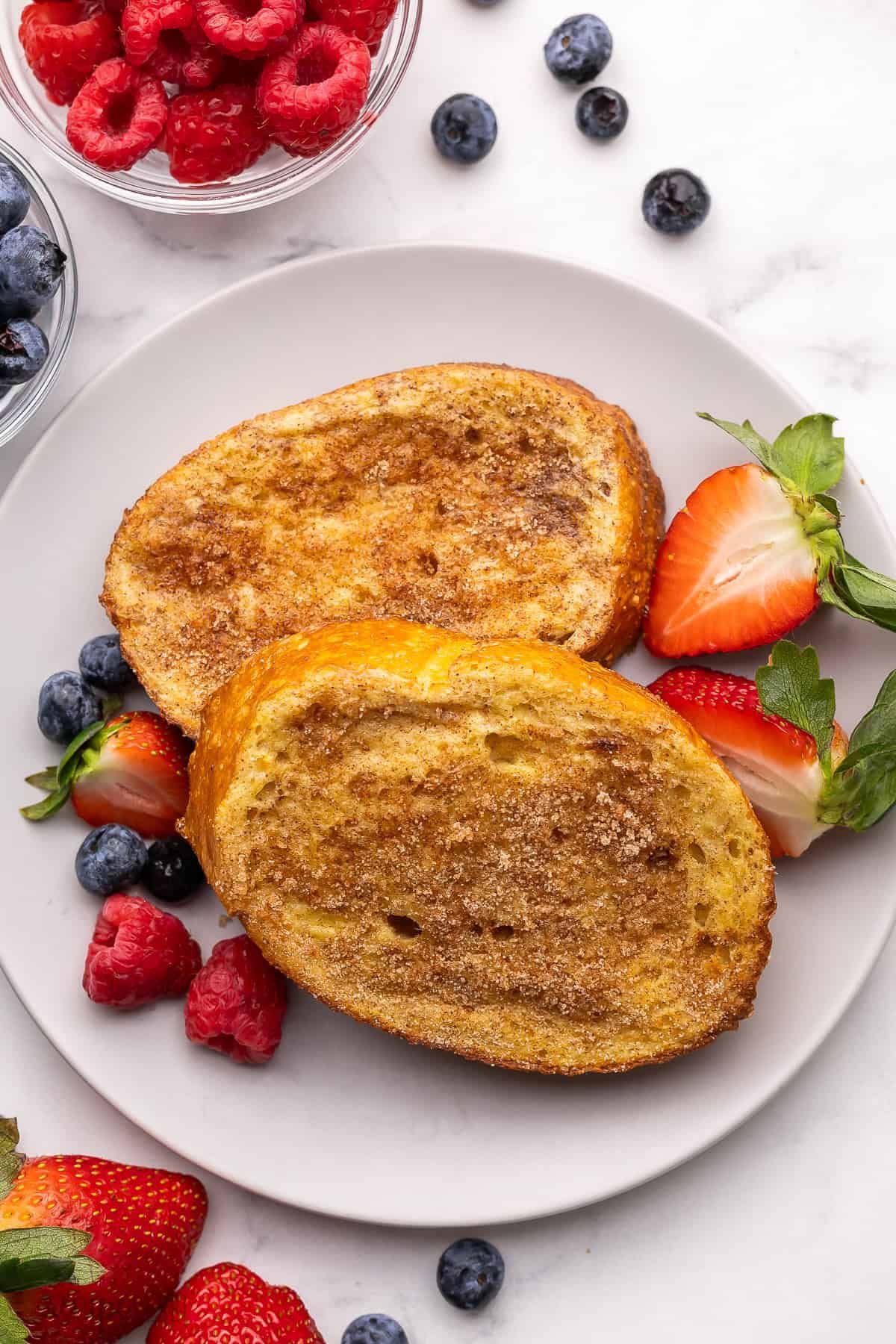 une assiette de pain perdu à la friteuse à air avec des baies à côté.