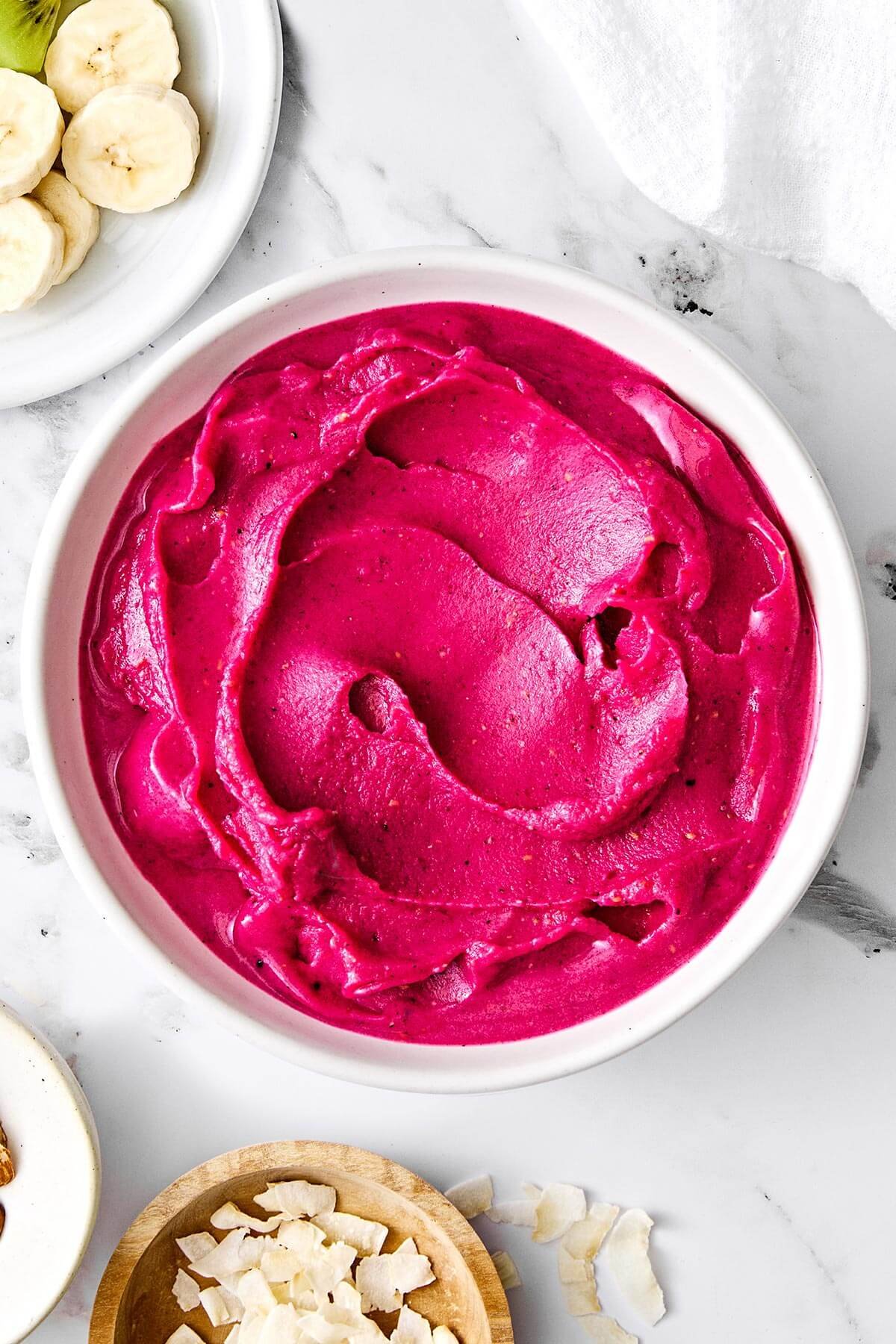 Rafraîchissant et riche en nutriments, ce bol de smoothie pitaya est le petit déjeuner léger ou l'en-cas sain parfait ! Un bol de pitaya mélangé.