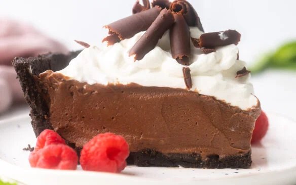 image carrée d'une tranche de tarte au chocolat français sur une assiette blanche.