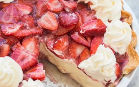 tarte entière à la crème de fraise avec un morceau manquant