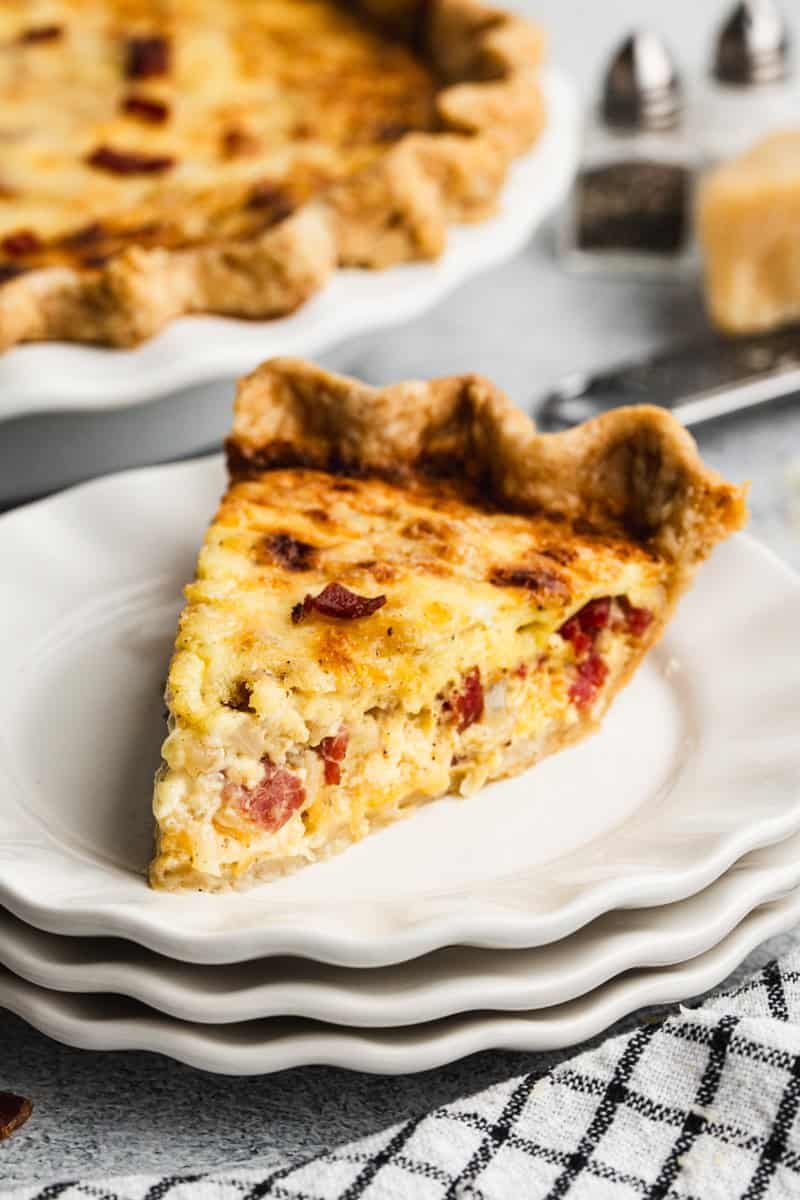 Cette quiche Lorraine a trois types de fromage différents ainsi que du bacon et des œufs dans une pâte brisée feuilletée. Elle peut être préparée jusqu'à deux jours à l'avance !