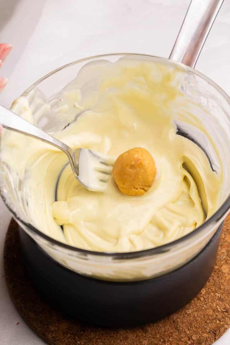 Truffes Oreo dorées plongées dans du chocolat blanc.