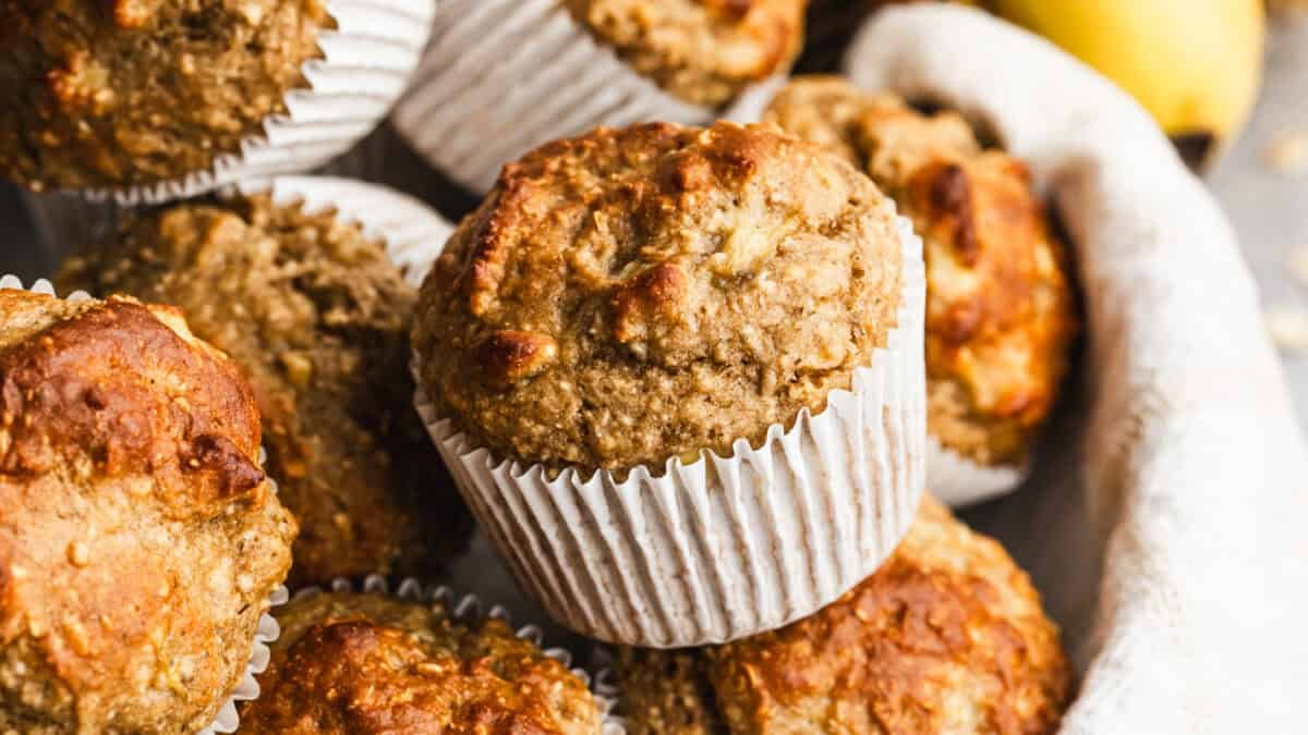 Cette recette de muffins à la banane riche en protéines est saine et contient des flocons d'avoine, des bananes, du yaourt grec, de la poudre de protéine, et est sucrée avec du sirop d'érable. Moelleux, aérés, et vous rassasient plus longtemps !