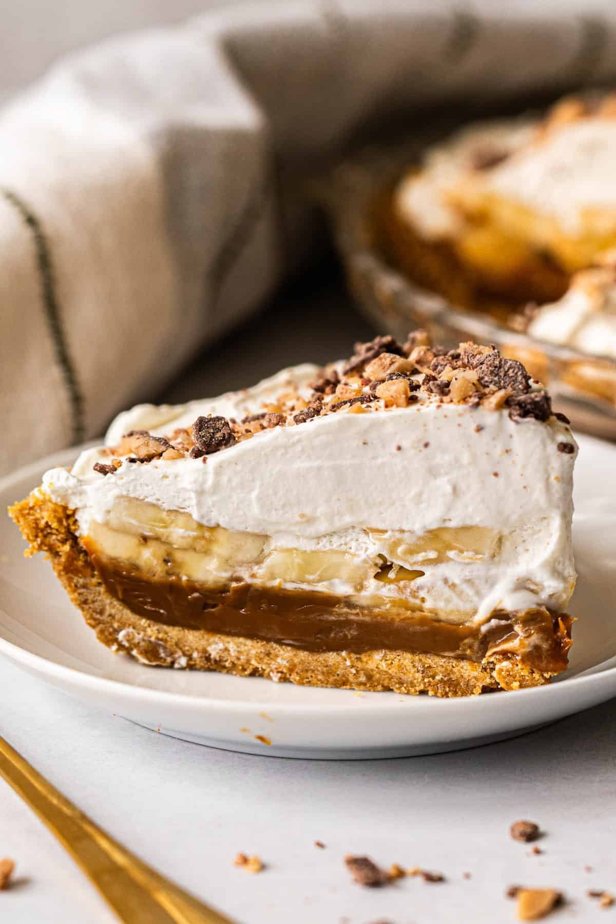 Cette tarte banoffee est la plus facile à réaliser et un favori instantané avec des couches de dulce de leche, de bananes et de crème fouettée fraîche sur une croûte de biscuits graham beurrés.