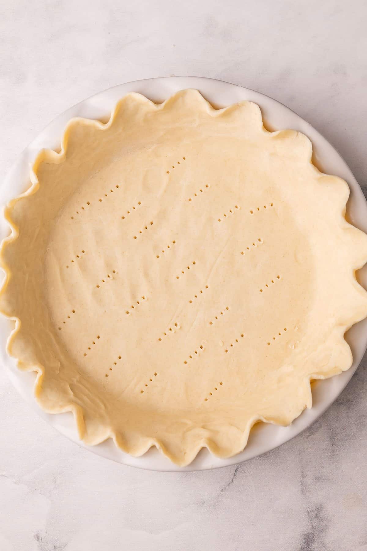 une croûte à tarte non cuite prête pour le four.