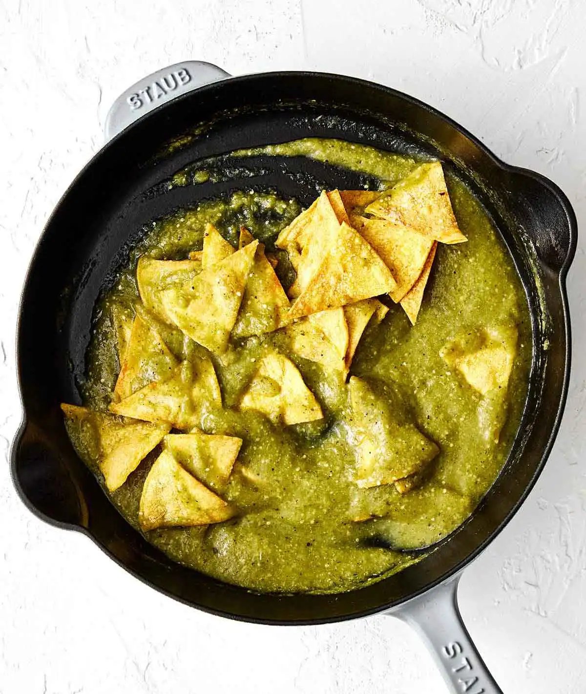 Étape trois chilaquiles : mélanger les chips avec la salsa.