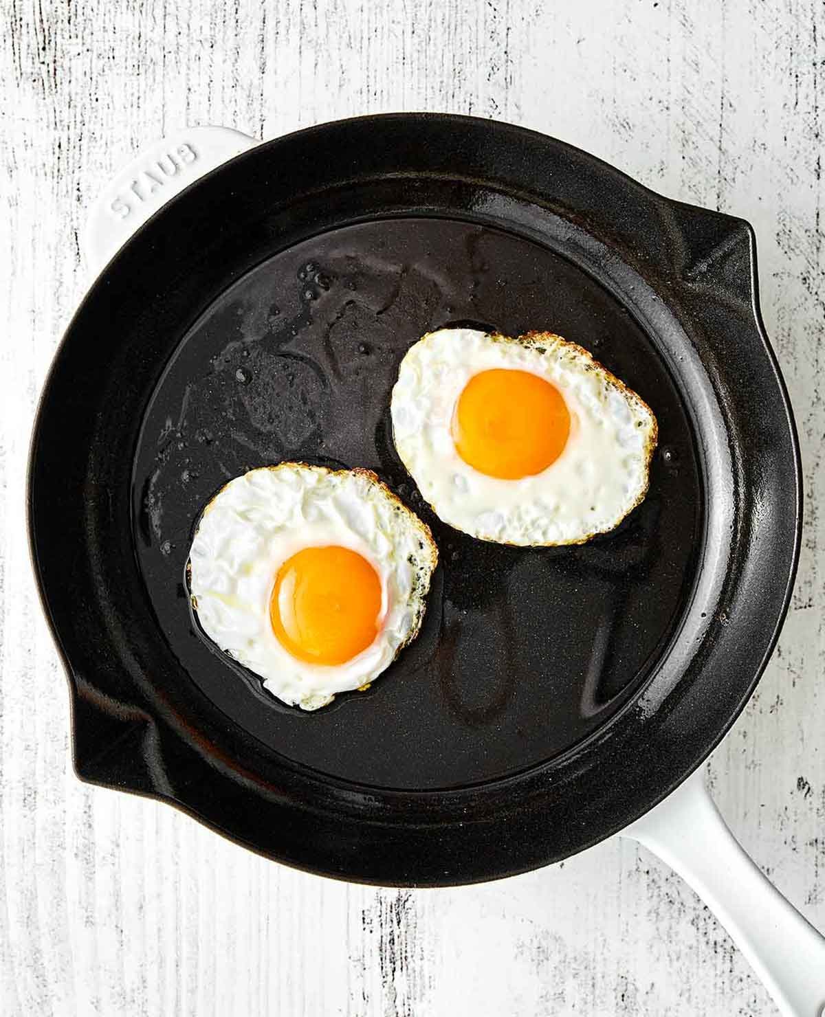 Faire frémir des œufs dans une poêle pour les huevos rancheros.