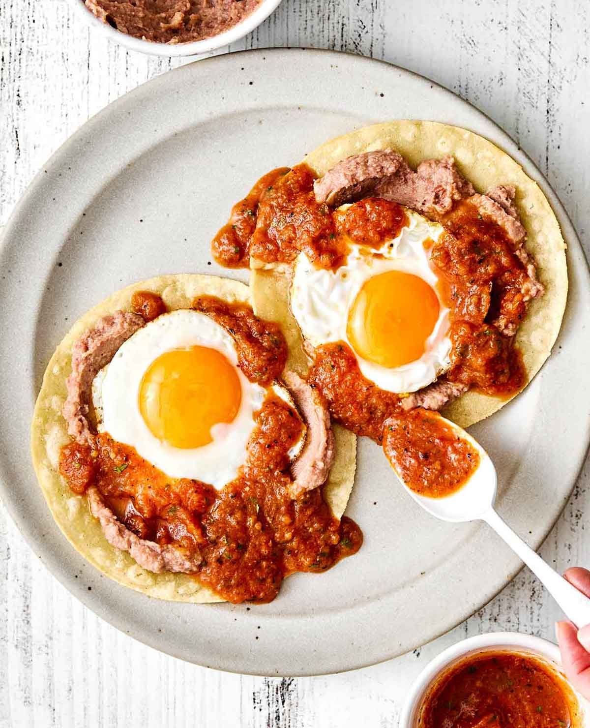 Ajouter de la sauce ranchero sur des huevos rancheros.