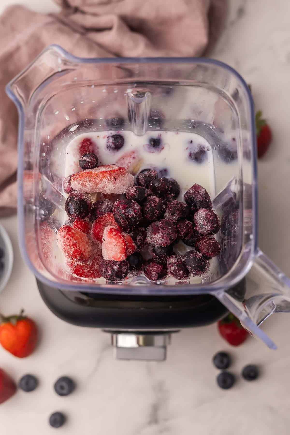 ingrédients pour le smoothie aux fruits rouges dans un mixeur.