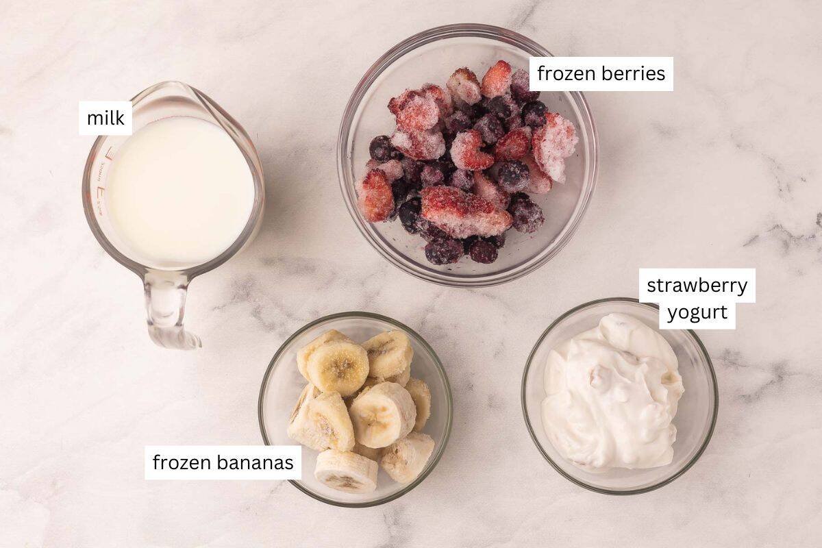 ingrédients pour la recette de smoothie aux fruits rouges sur fond marbré.