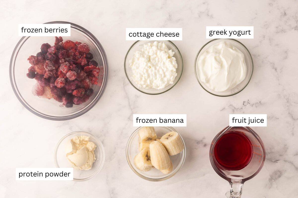 ingrédients nécessaires pour un smoothie protéiné sur un fond en marbre blanc.
