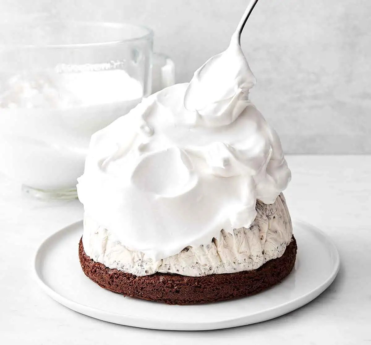 Ajout de la meringue sur la couche de glace pour un Baked Alaska.