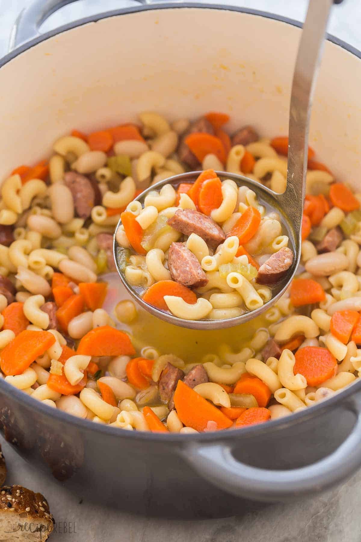Cuillère servant la soupe minestrone avec saucisse fumée